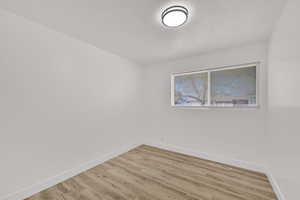 Spare room featuring a textured ceiling and light wood-type flooring