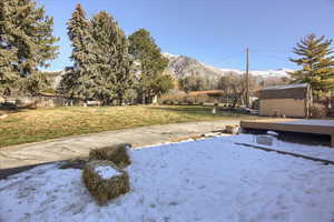 Yard layered in snow featuring a yard and a mountain view