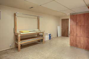 Basement with light floors and a paneled ceiling