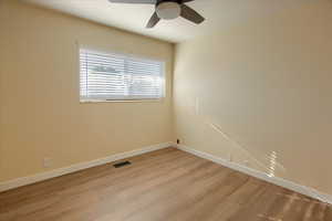 Empty room featuring light wood-style floors and a ceiling fan