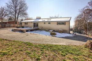 Back of house with a fenced backyard, a wooden deck, a chimney, and brick siding
