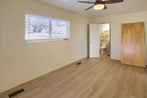 Unfurnished bedroom with a closet, light wood-type flooring, and a ceiling fan
