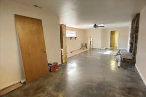 Below grade area featuring a ceiling fan and a textured ceiling