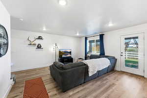 Living room with light LVP finished floors and recessed lighting