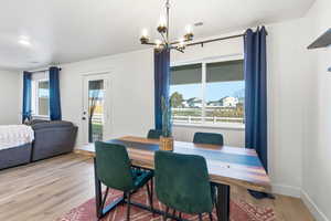 Dining space with light wood finished floors and a chandelier