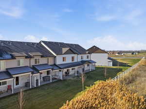 Rear view of house featuring a patio, a residential view, and stone siding