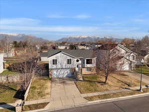 Split foyer home featuring driveway, a residential view, and a mountain view