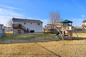 Back of property with a fenced backyard, stairs, and deck
