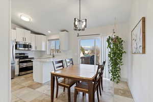 Dining space with vaulted ceiling and a chandelier