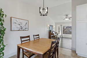 Dining space with a chandelier, vaulted ceiling, and ceiling fan