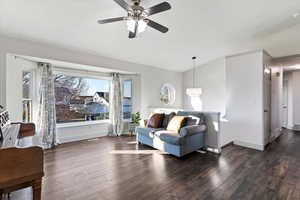 Living room featuring vaulted ceiling, laminate flooring, and ceiling fan