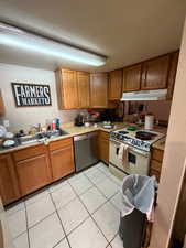 Kitchen featuring brown cabinets, light countertops, and stainless steel dishwasher