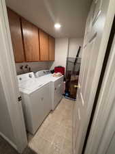 Washroom featuring cabinet space and washing machine and dryer