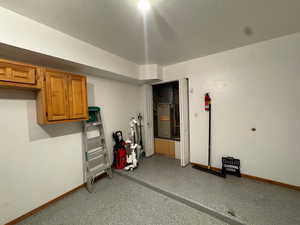 Finished garage featuring baseboards and e-charger