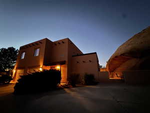 View of side of property featuring a gate and stucco siding