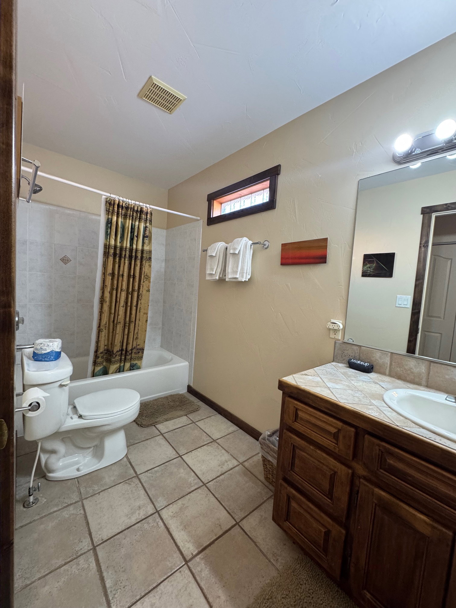 Bathroom with shower / bathtub combination with curtain, vanity, and light tile patterned floors