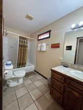 Bathroom with shower / bathtub combination with curtain, vanity, and light tile patterned floors
