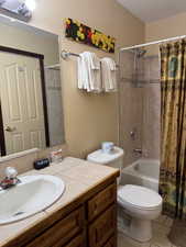 Bathroom featuring vanity, shower / bath combo, and light tile patterned floors