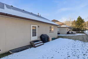 View of snowy exterior with stucco siding