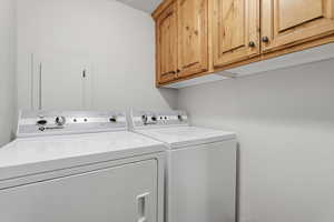 Laundry room featuring separate washer and dryer and cabinet space