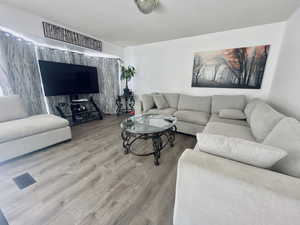 Living room with a textured ceiling and wood finished floors