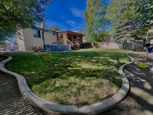 Rear view of property with a fenced backyard, a deck, and a chimney
