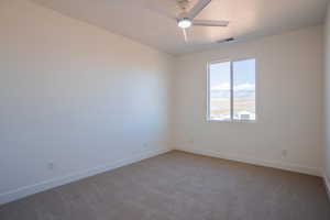 Spare room featuring light carpet and a ceiling fan