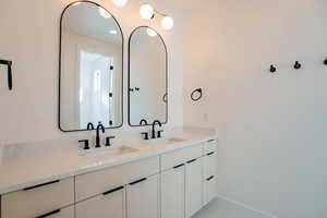 Bathroom with double vanity and baseboards