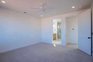 Unfurnished bedroom featuring recessed lighting, light carpet, a ceiling fan, and ensuite bathroom