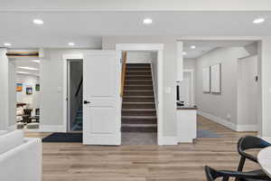 Stairway featuring wood finished floors and recessed lighting