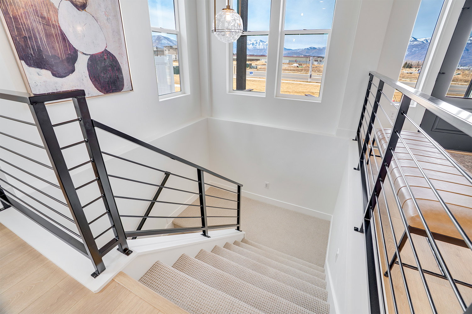 Stairway with a mountain view, plenty of natural light, and a chandelier