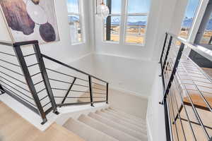 Stairway with a mountain view, plenty of natural light, and a chandelier