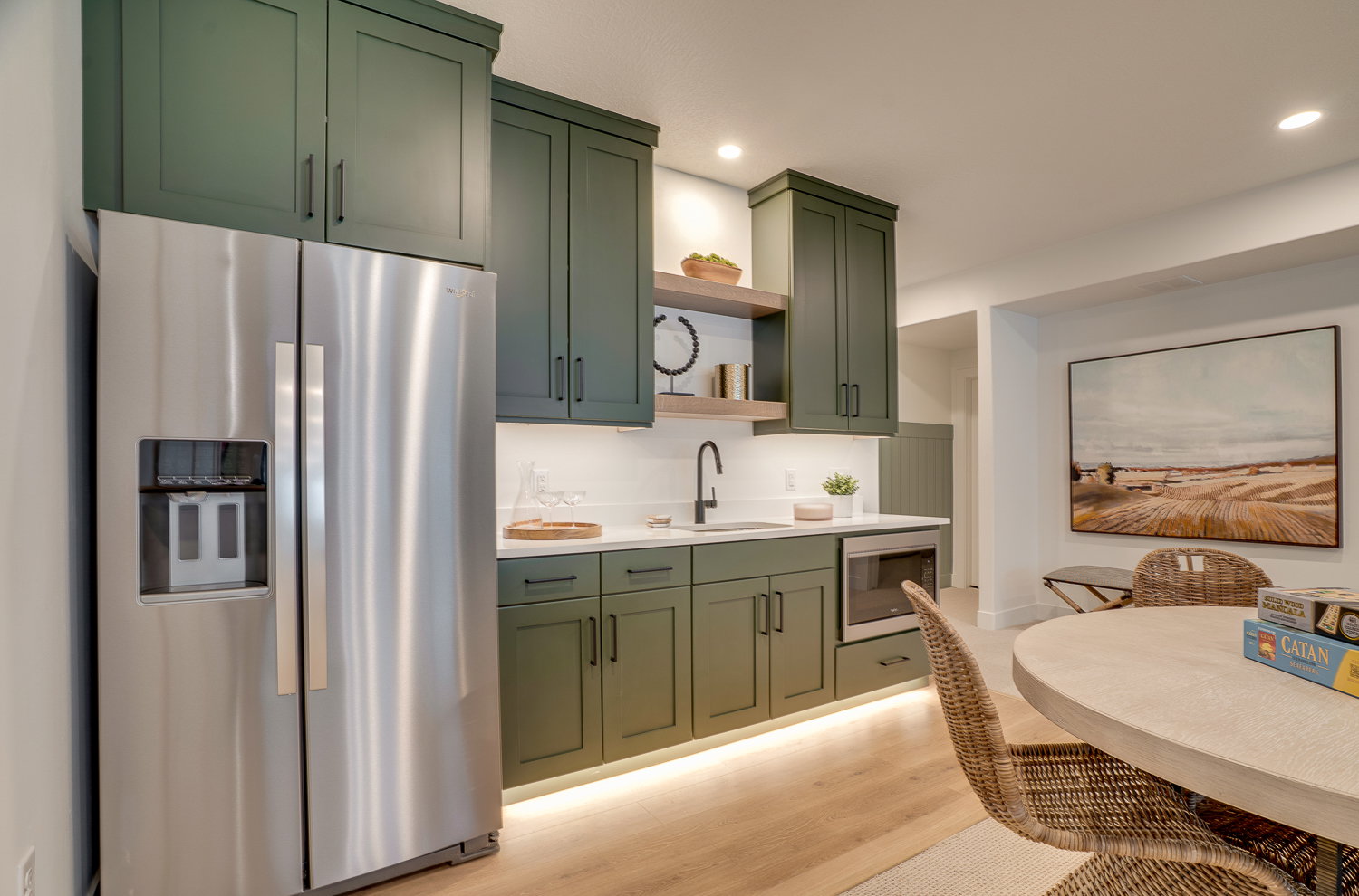Kitchen with green cabinetry, stainless steel appliances, open shelves, light wood-style flooring, and recessed lighting