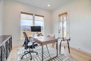 Office area featuring light wood-type flooring and recessed lighting
