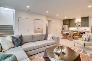 Living room featuring recessed lighting and stairs