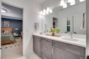 Full bath featuring double vanity and connected bathroom