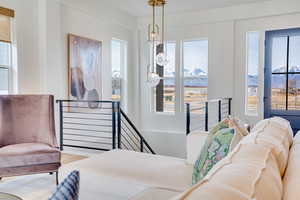 Living area with an upstairs landing, a chandelier, light wood-style floors, and a mountain view
