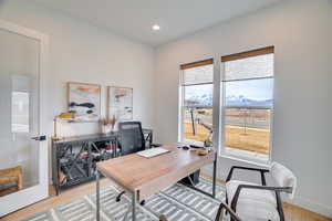 Office area featuring light wood finished floors, a mountain view, and recessed lighting