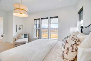 Bedroom with light colored carpet and multiple windows