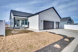 View of front of home with concrete driveway, board and batten siding, a mountain view, a garage, and a shingled roof
