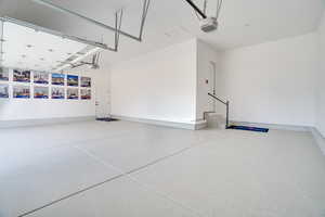 Garage featuring a garage door opener and baseboards