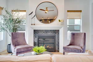 Sitting room featuring wood finished floors, a tiled fireplace, and ceiling fan