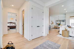 Hall with recessed lighting, light wood-type flooring, and a chandelier
