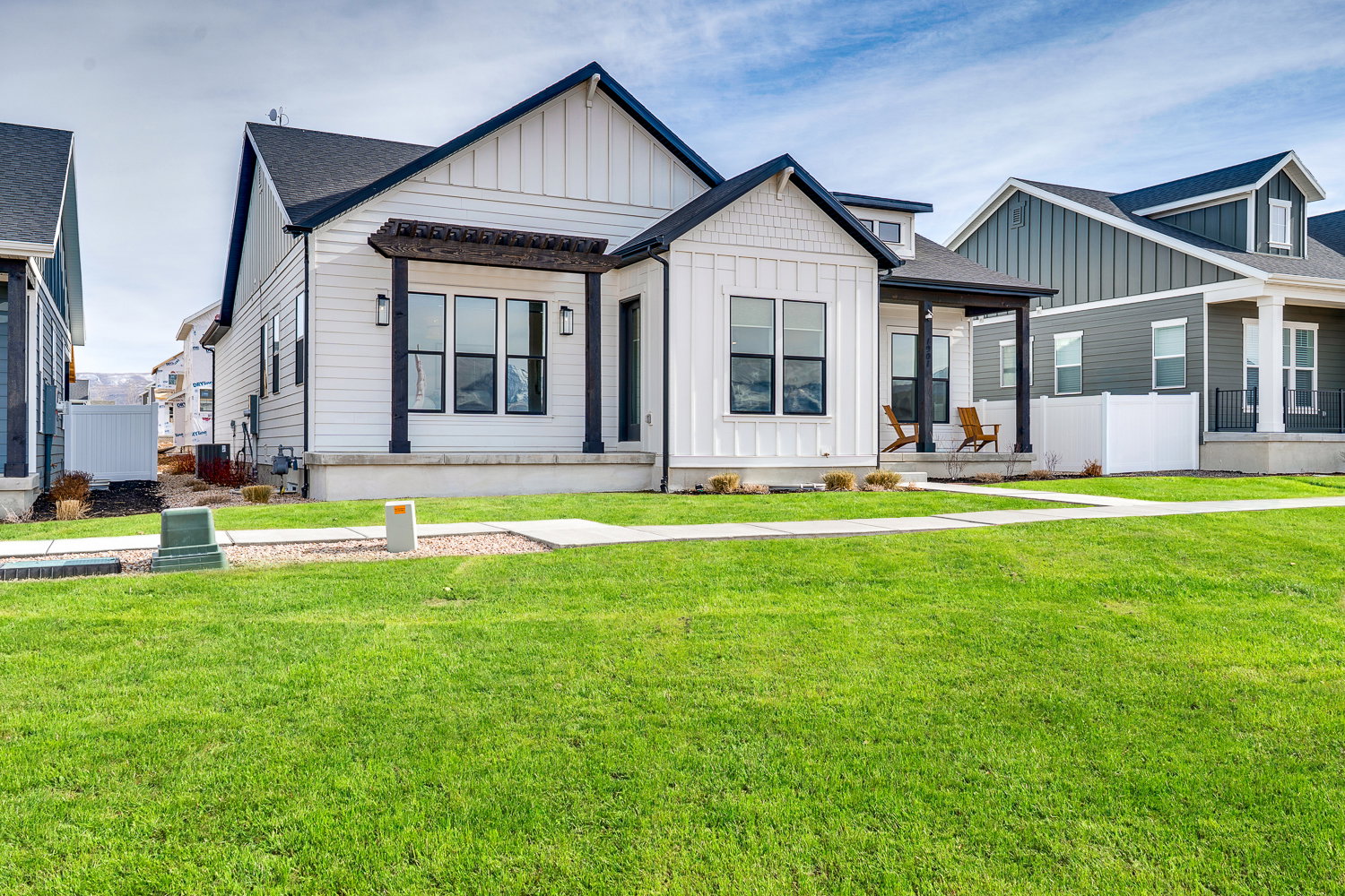 Modern inspired farmhouse with board and batten siding, a porch, and roof with shingles