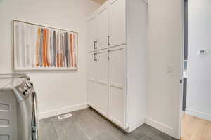 Washroom with washer and dryer and baseboards