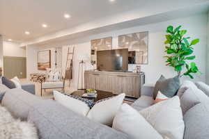 Living area with a wainscoted wall and recessed lighting