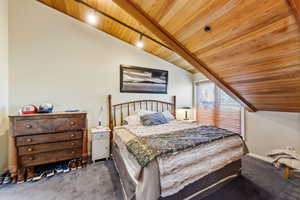 Carpeted bedroom with wood ceiling and lofted ceiling