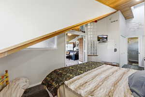 Bedroom with wood ceiling, carpet, high vaulted ceiling, and ensuite bathroom