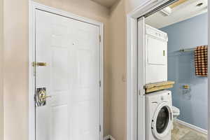 Laundry area with stacked washer / dryer and baseboards
