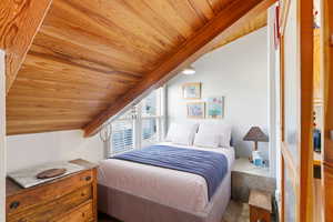 Bedroom with vaulted ceiling and wood ceiling